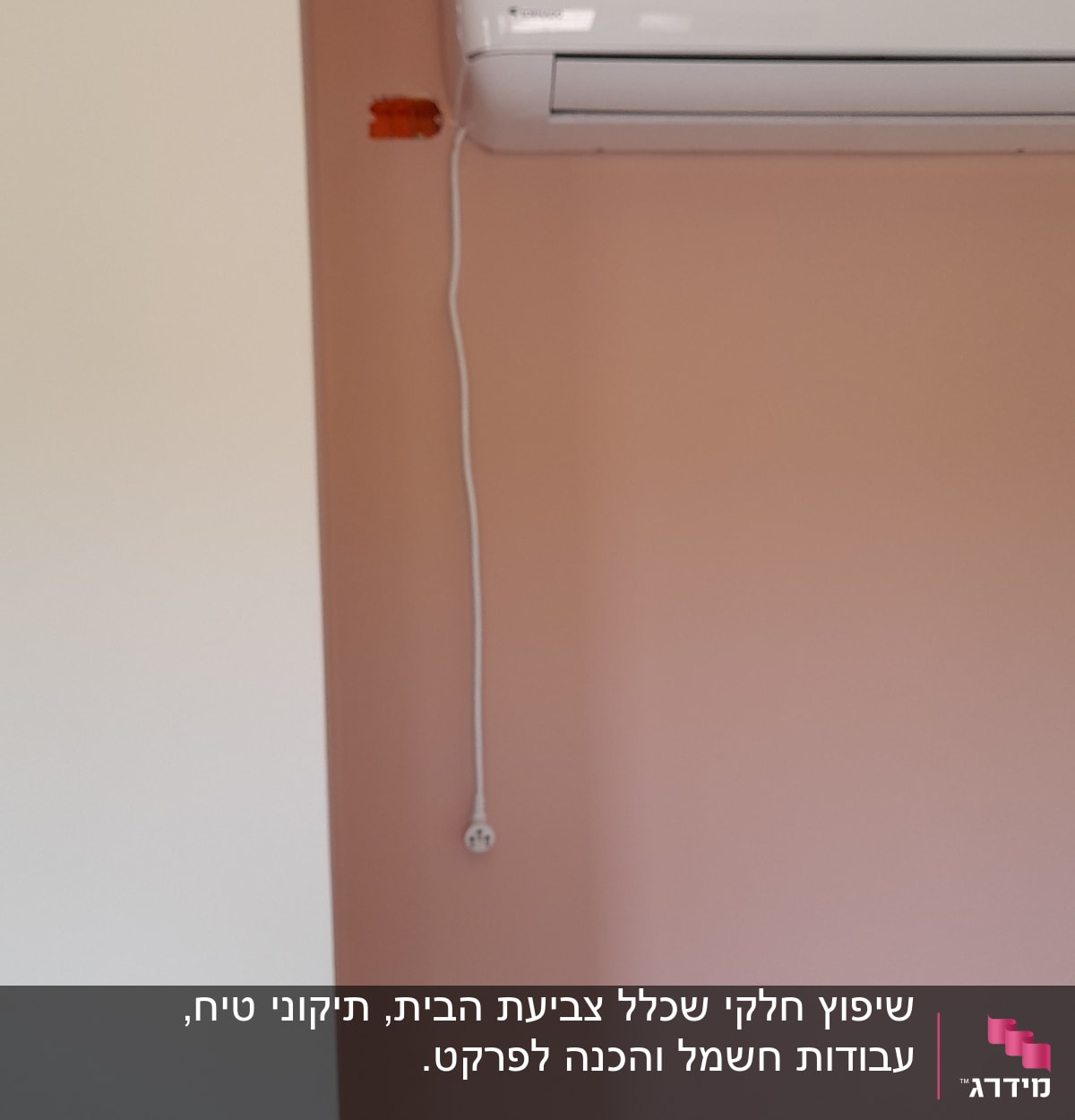מזגן מותקן על קיר עם חוט חשמל גלוי